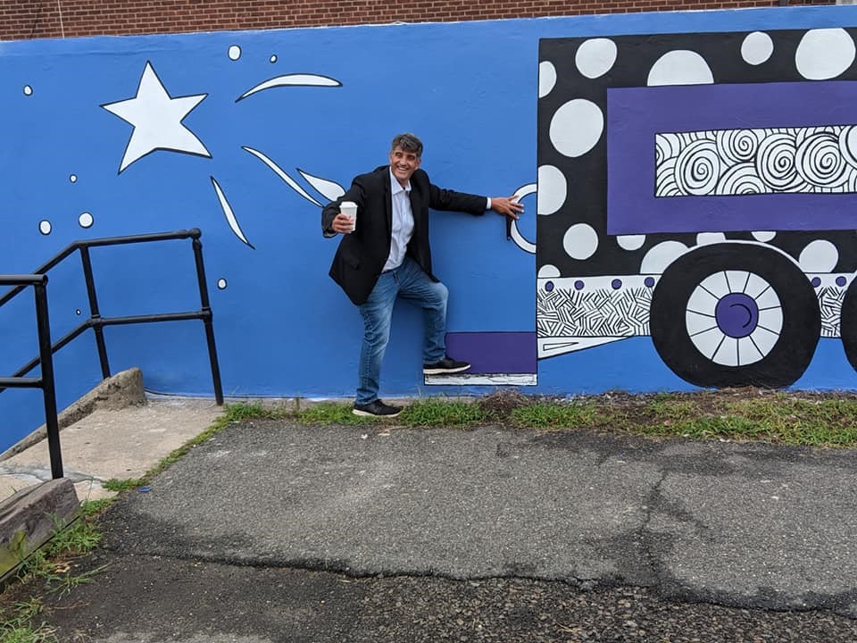 City of Garfield Mayor Richard Rigoglioso “catches the train” in front of the new mural in the River to Rail District